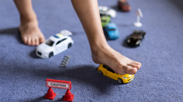 Kind rutscht auf Spielsachen aus