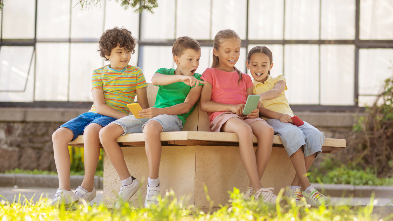 Viele Kinder die auf einer Bank sitzen 
