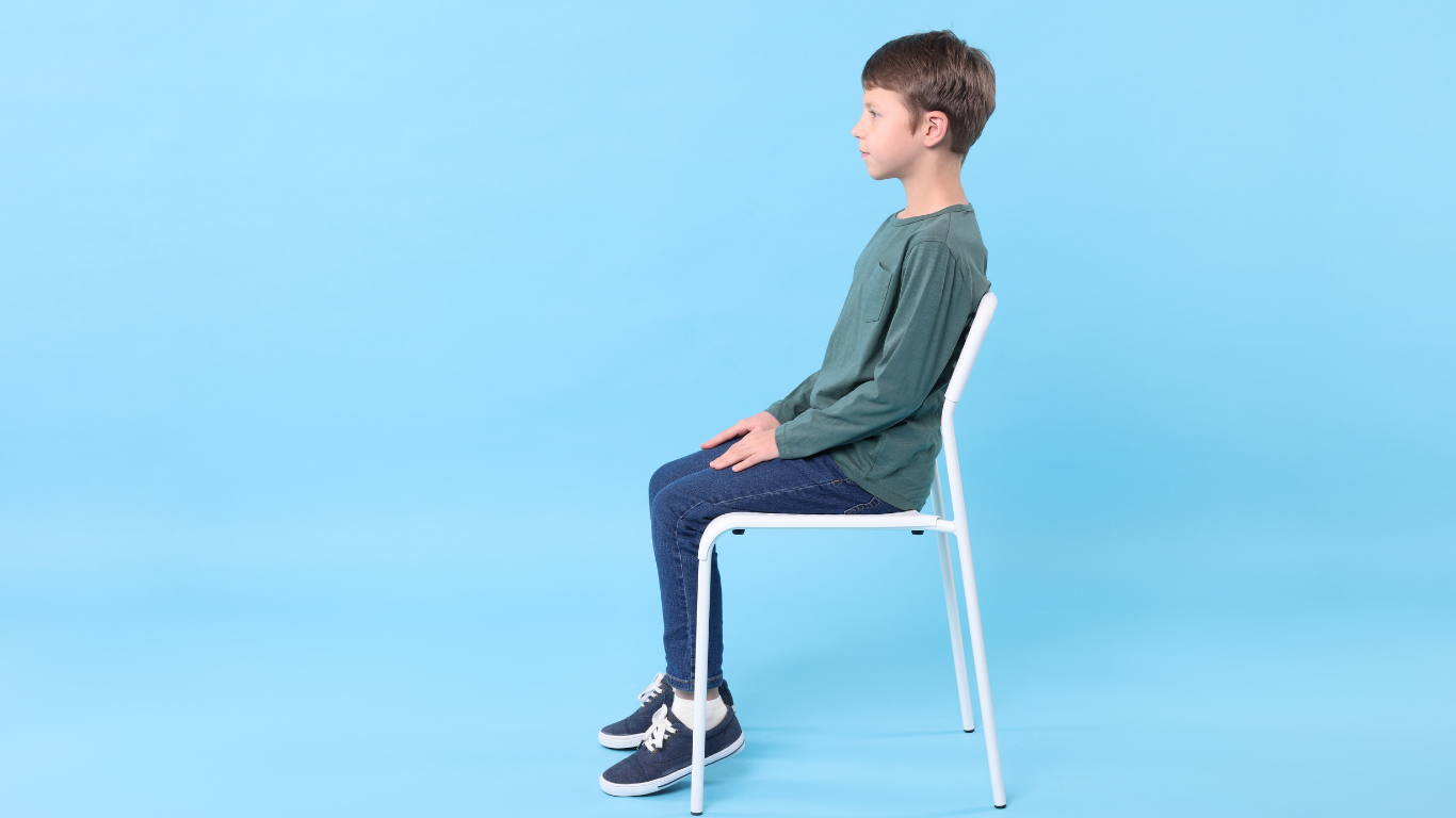Kind sitzt auf einem Stuhl mit gerader Haltung