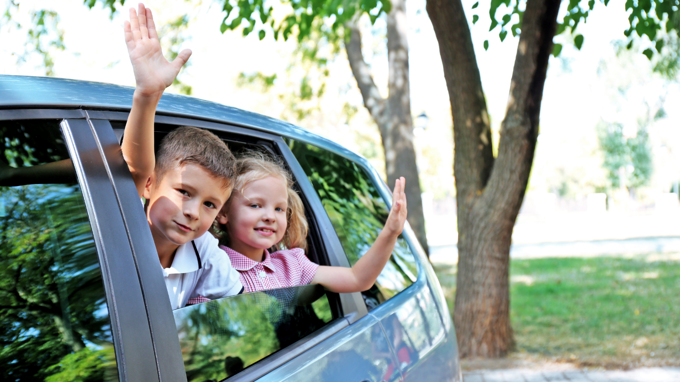 ein Mädchen und ein Bub, die im Autos sitzen