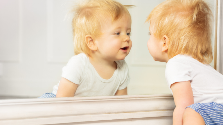 Baby schaut in den Spiegel